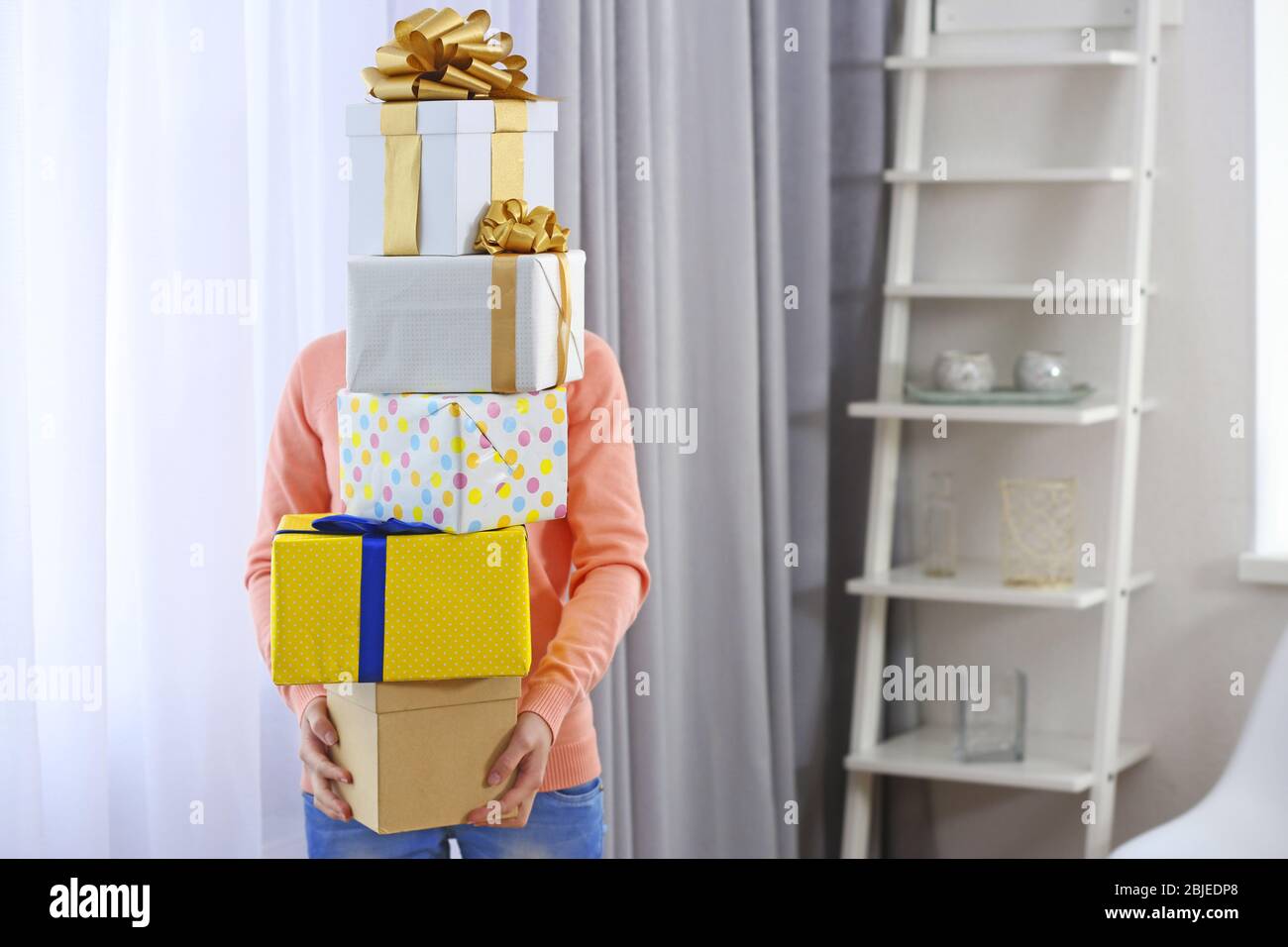 Donna con mucchio di regali a casa Foto Stock