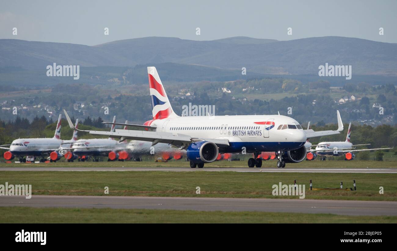 Glasgow, Regno Unito. 28 aprile 2020. Nella foto: Un volo British Airways da Londra Heathrow arriva a Glasgow (con Airbus BA Jets a terra in background), uno dei pochi voli di linea che oggi arrivano a Glasgow durante la crisi Coronavirus (COVID-19) UK Extended Lockdown. Ad oggi British Airways ha fatto un annuncio che vede quasi 12,000 dipendenti assetati reagendo alla pandemia che ha colpito ogni grande compagnia aerea, mettendo alcuni fuori commercio. Credit: Colin Fisher/Alamy Live News. Foto Stock