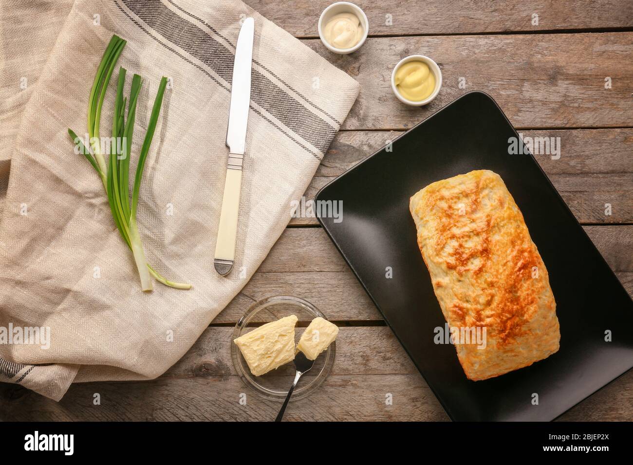 Piatto con gustosa focaccia di birra su sfondo di legno Foto Stock