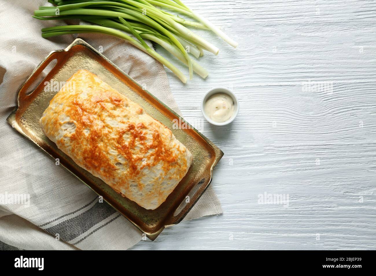 Vassoio di rame con gustosa focaccia di birra sul tavolo in legno Foto Stock