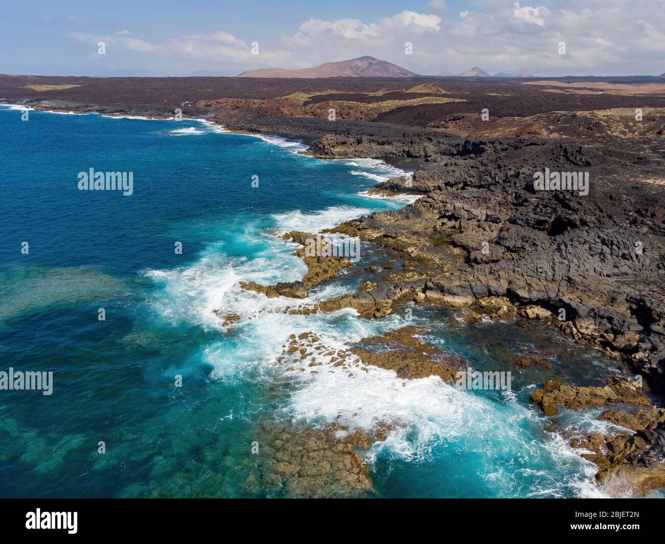 Vista aerea della spiaggia paradisiaca con sabbia nera e paesaggio vulcanico a Lanzarote, Isole Canarie Foto Stock