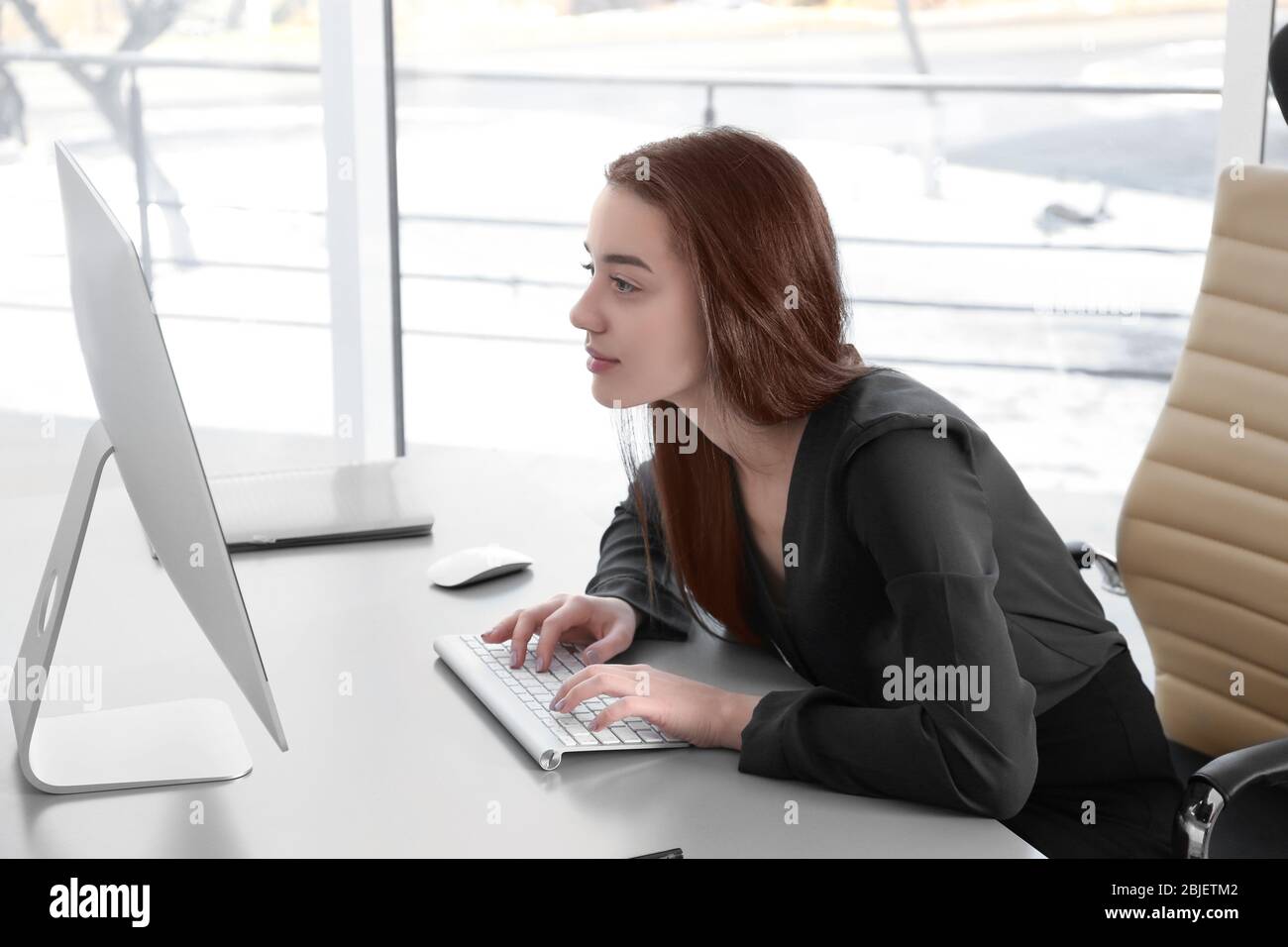 Concetto di postura. Giovane donna che lavora con il computer in ufficio Foto Stock