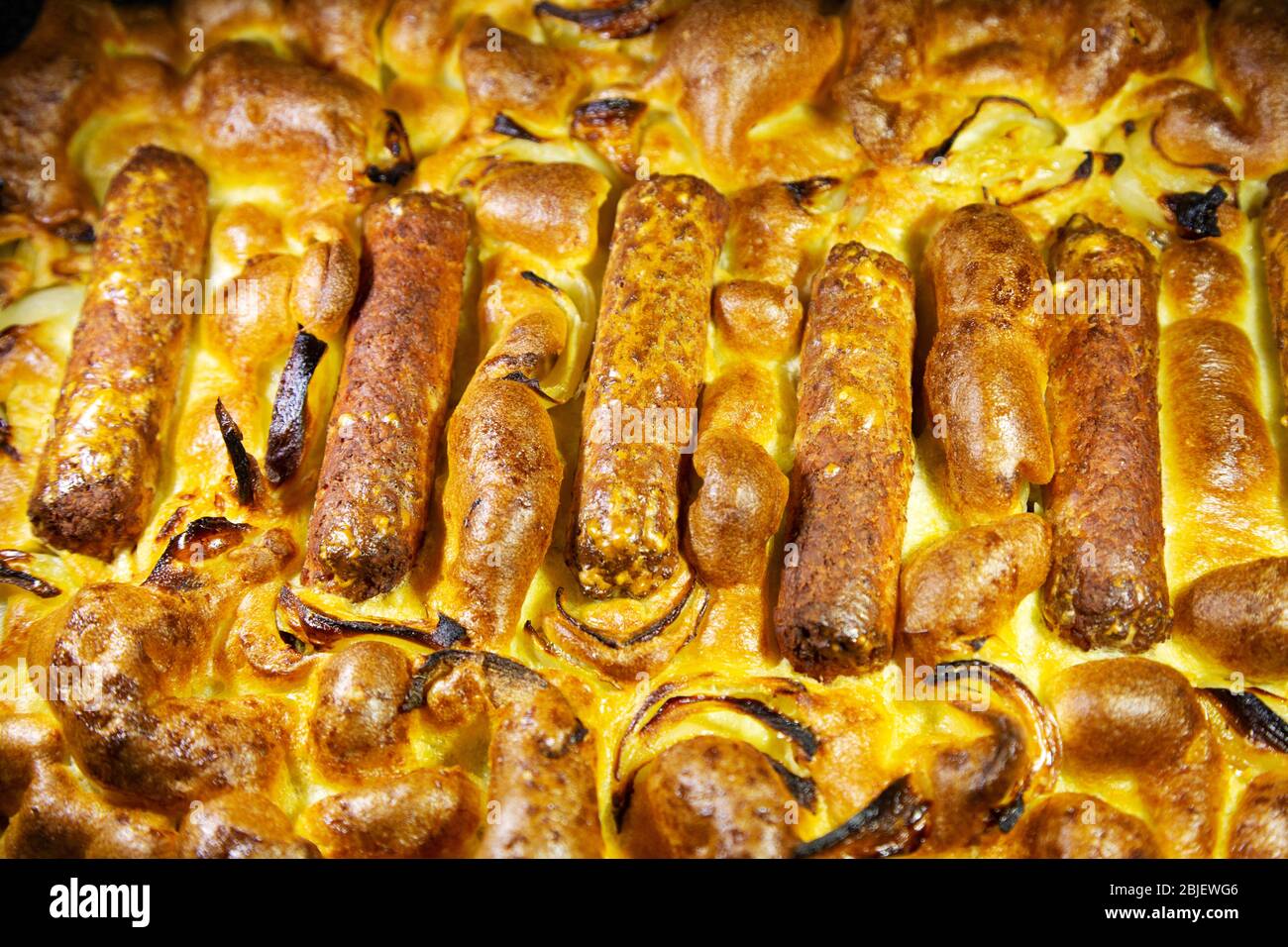 Toad vegetariano cotto in casa nel buco. Il piatto è preparato con salsicce vegetariane e pastella. Foto Stock