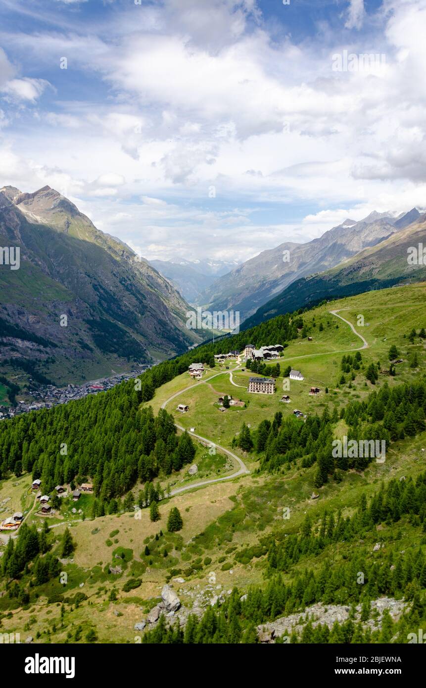 Paesaggio montano e la valle di materia sotto, come si vede in una giornata nuvolosa d'estate da Riffelberg, Svizzera Foto Stock