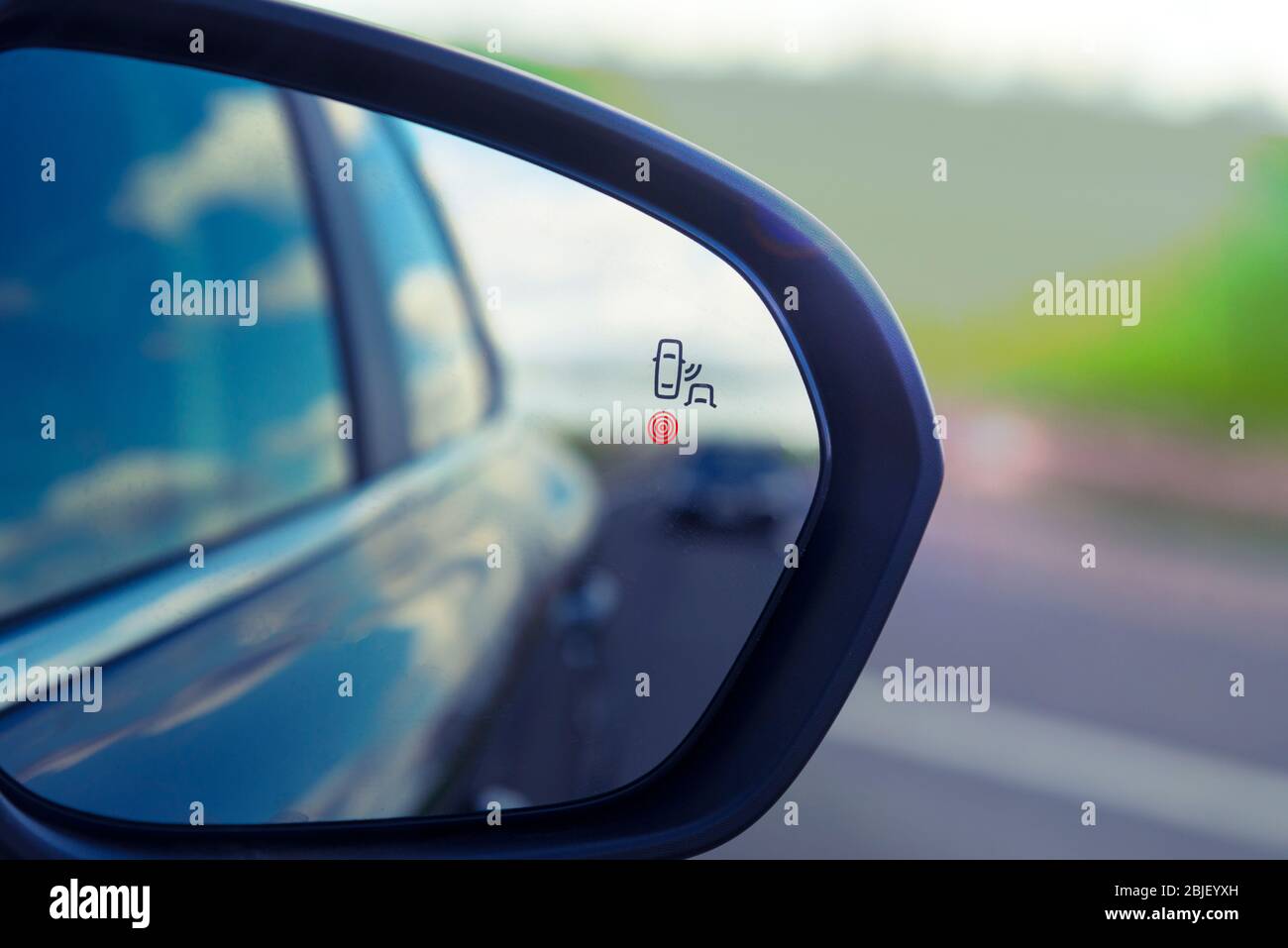 sensore di monitoraggio zona cieca sullo specchietto retrovisore di una vettura moderna Foto Stock