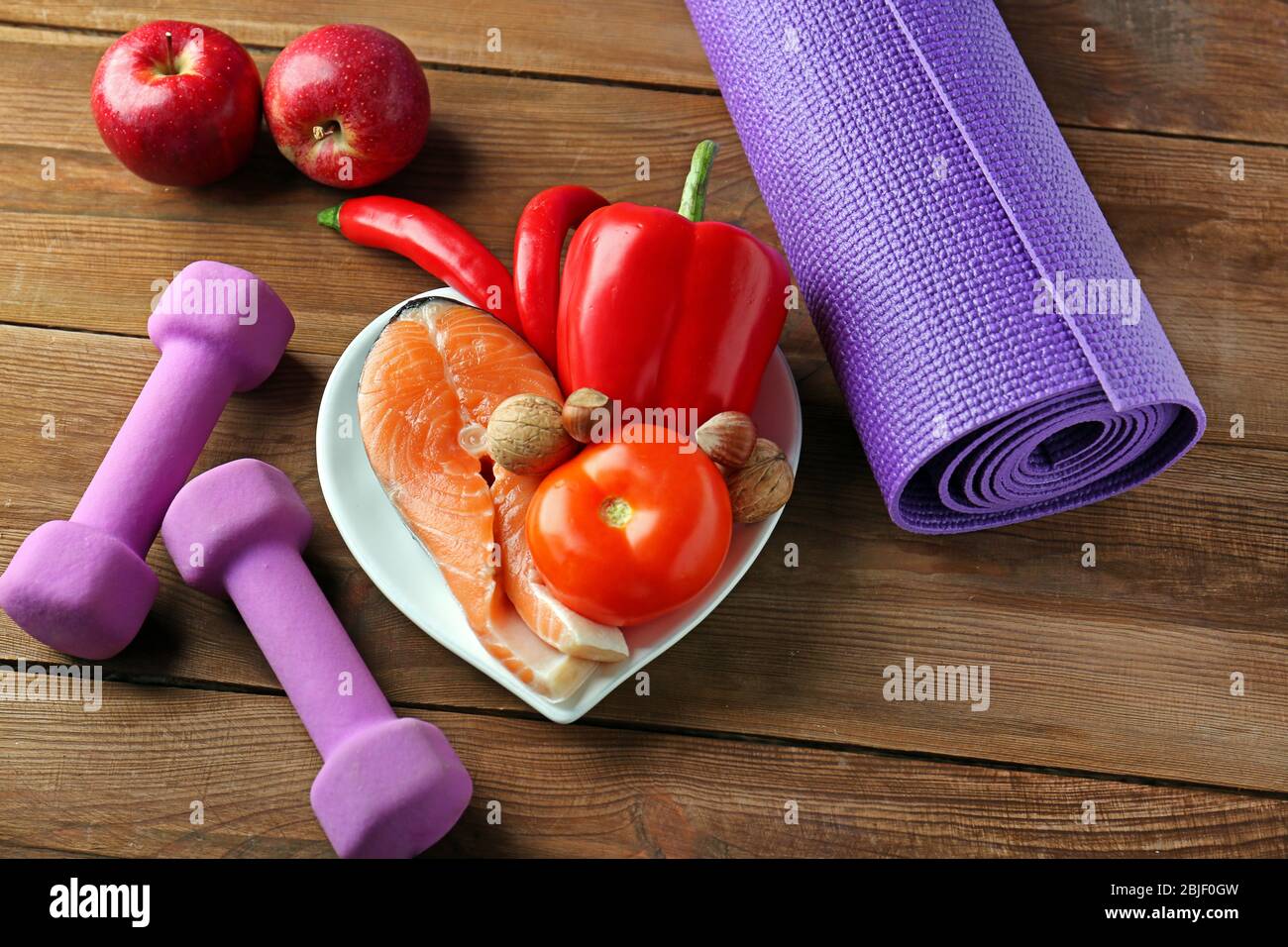 Cibo sano, manubri e manto su sfondo di legno Foto Stock