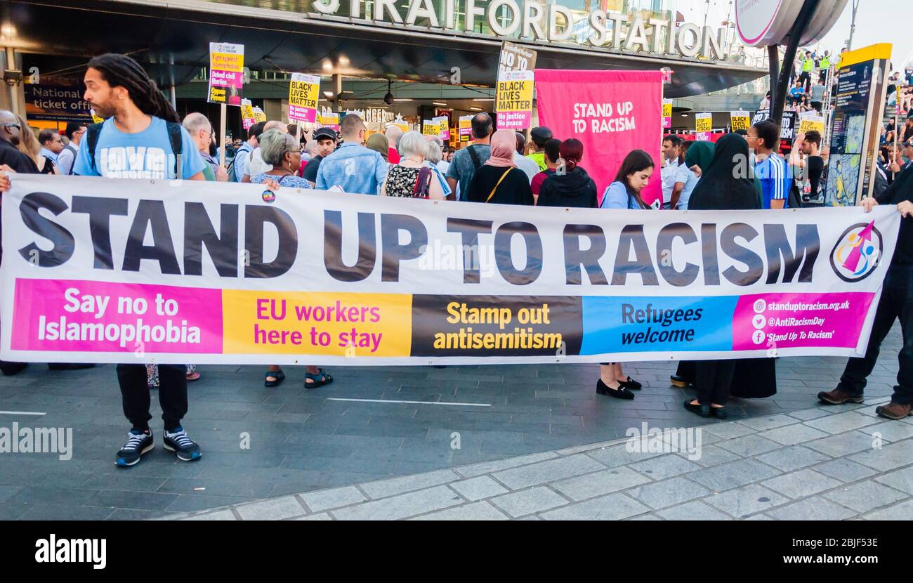 La protesta degli "ATTACCHI DI STOP ACID" si trova al di fuori della stazione di Stratford a Londra Est. I manifestanti stanno tenendo un banner con la scritta "tand up to Racism" (Sida fino al razzismo) Foto Stock