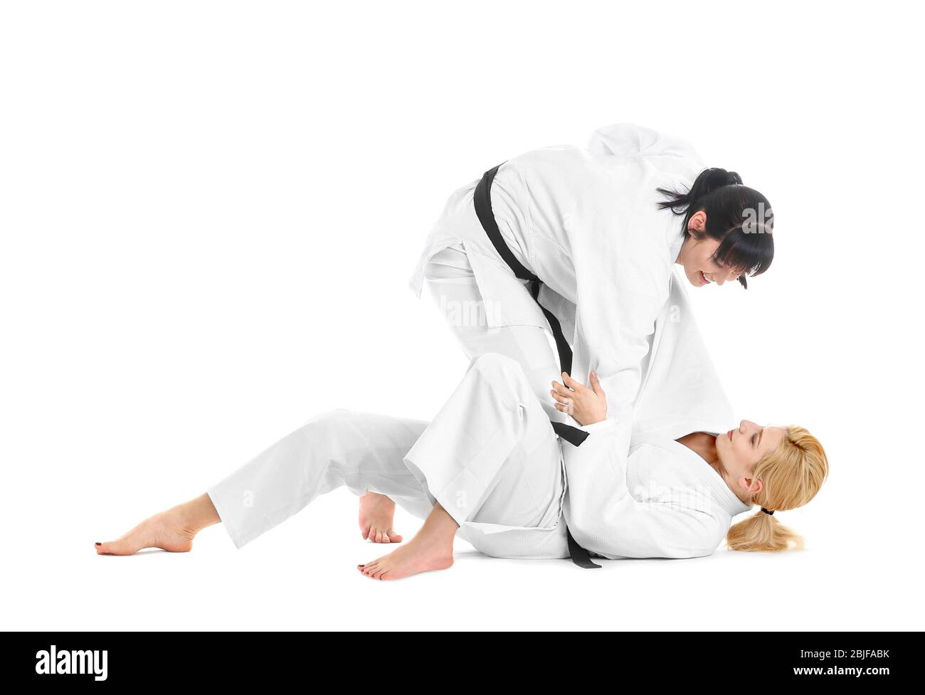Giovani donne sportive che praticano arti marziali su sfondo bianco Foto Stock