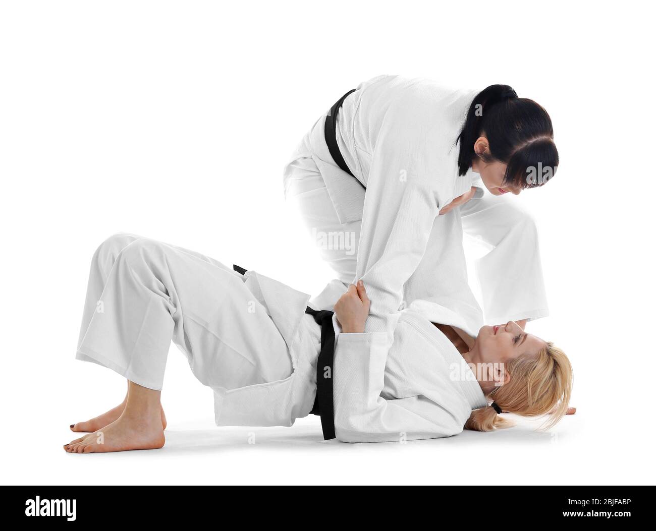 Giovani donne sportive che praticano arti marziali su sfondo bianco Foto Stock