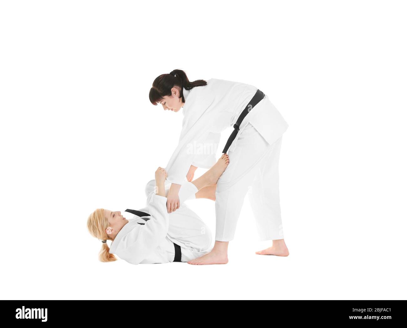 Giovani donne sportive che praticano arti marziali su sfondo bianco Foto Stock