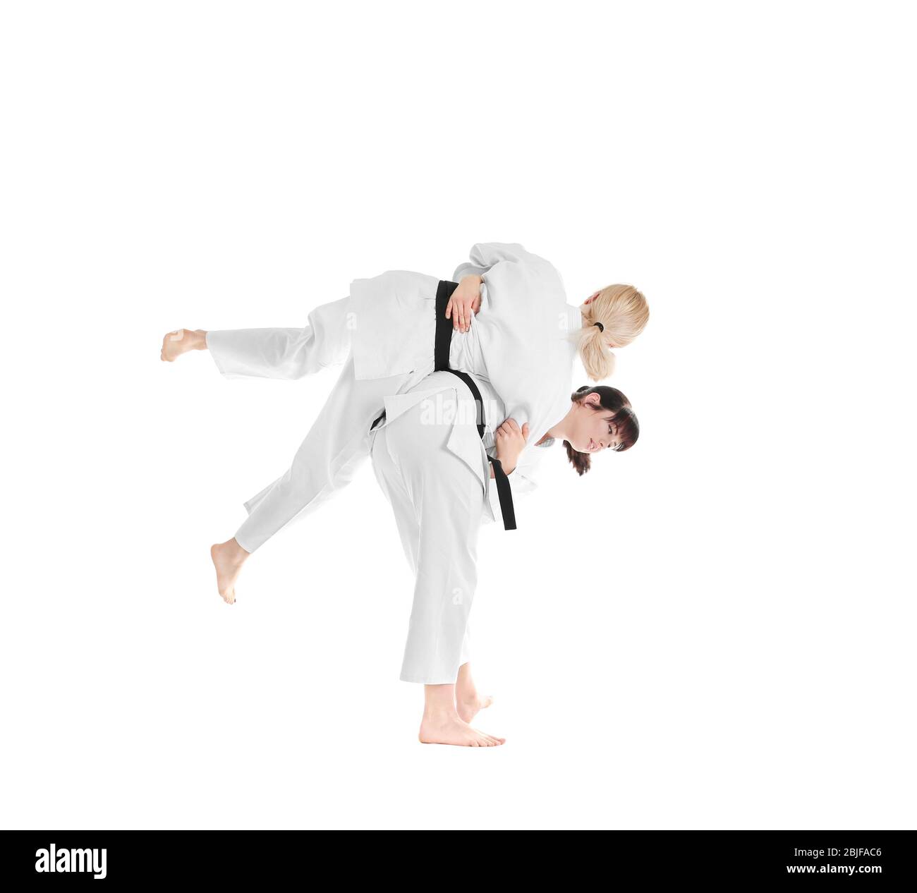 Giovani donne sportive che praticano arti marziali su sfondo bianco Foto Stock