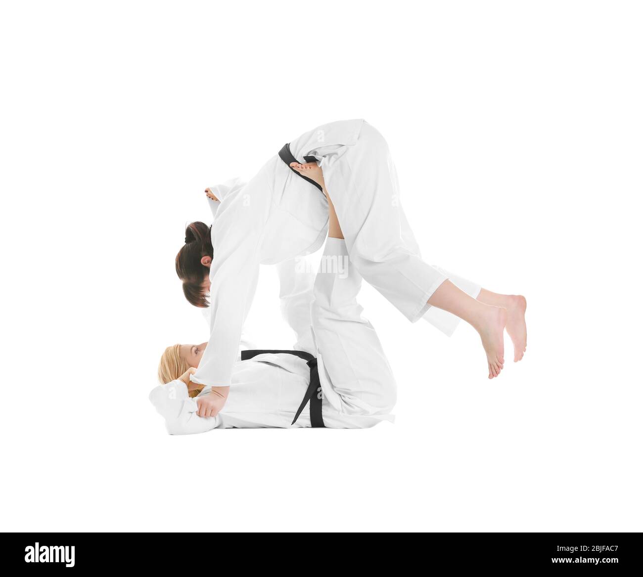 Giovani donne sportive che praticano arti marziali su sfondo bianco Foto Stock