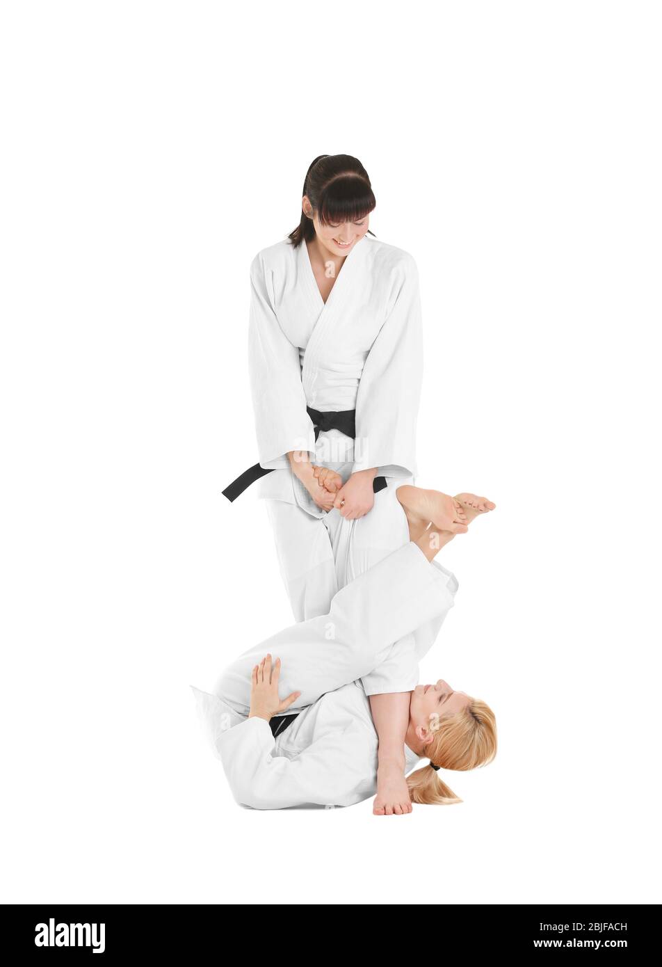Giovani donne sportive che praticano arti marziali su sfondo bianco Foto Stock