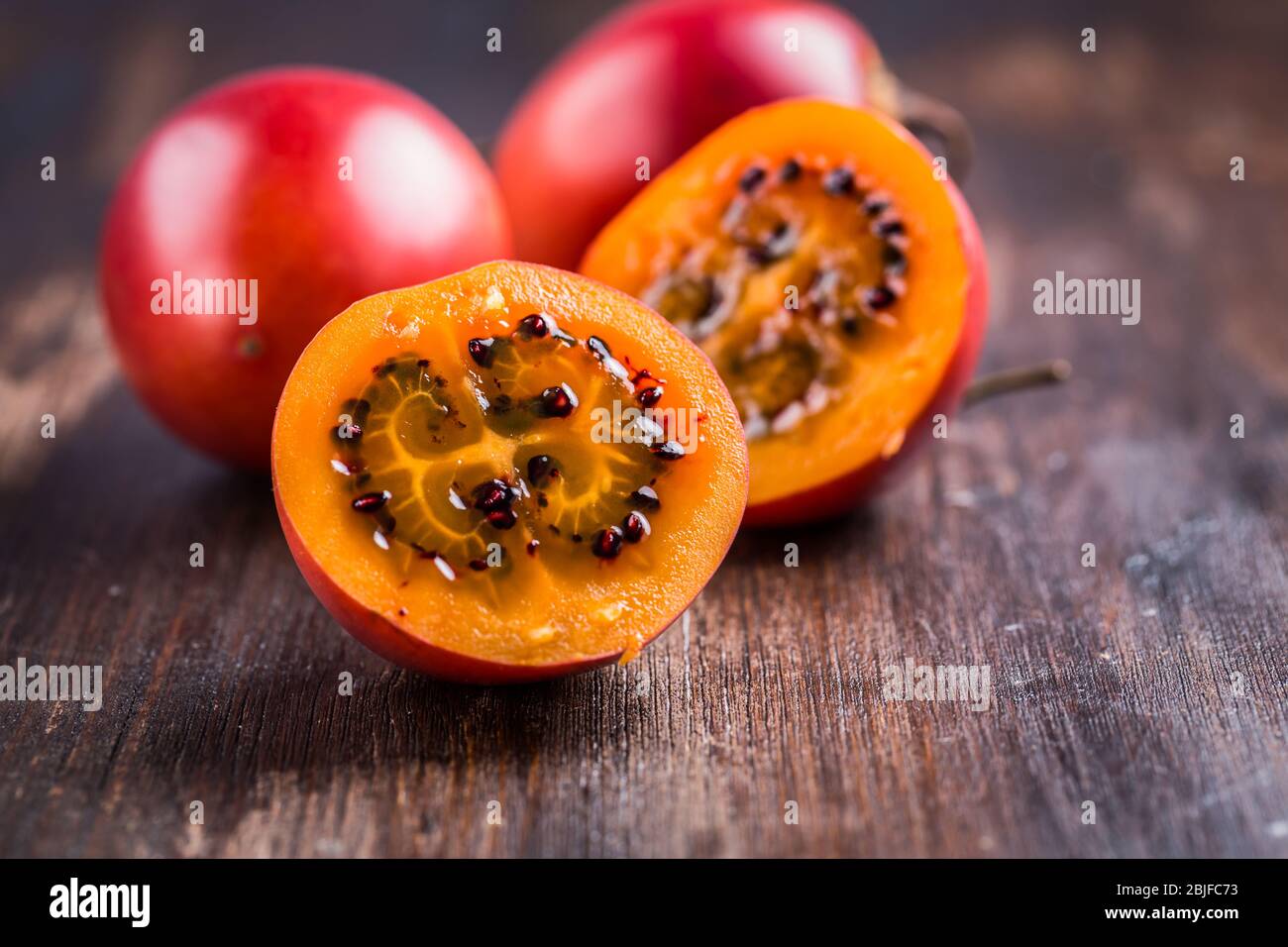 Frutta fresca tamarillo su sfondo legno Foto Stock