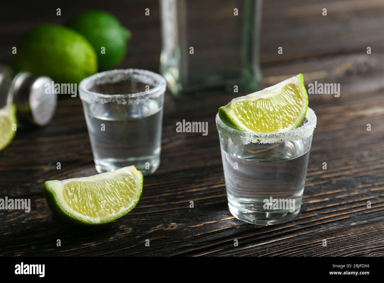 Tequila con fette di lime e sale sul tavolo Foto Stock