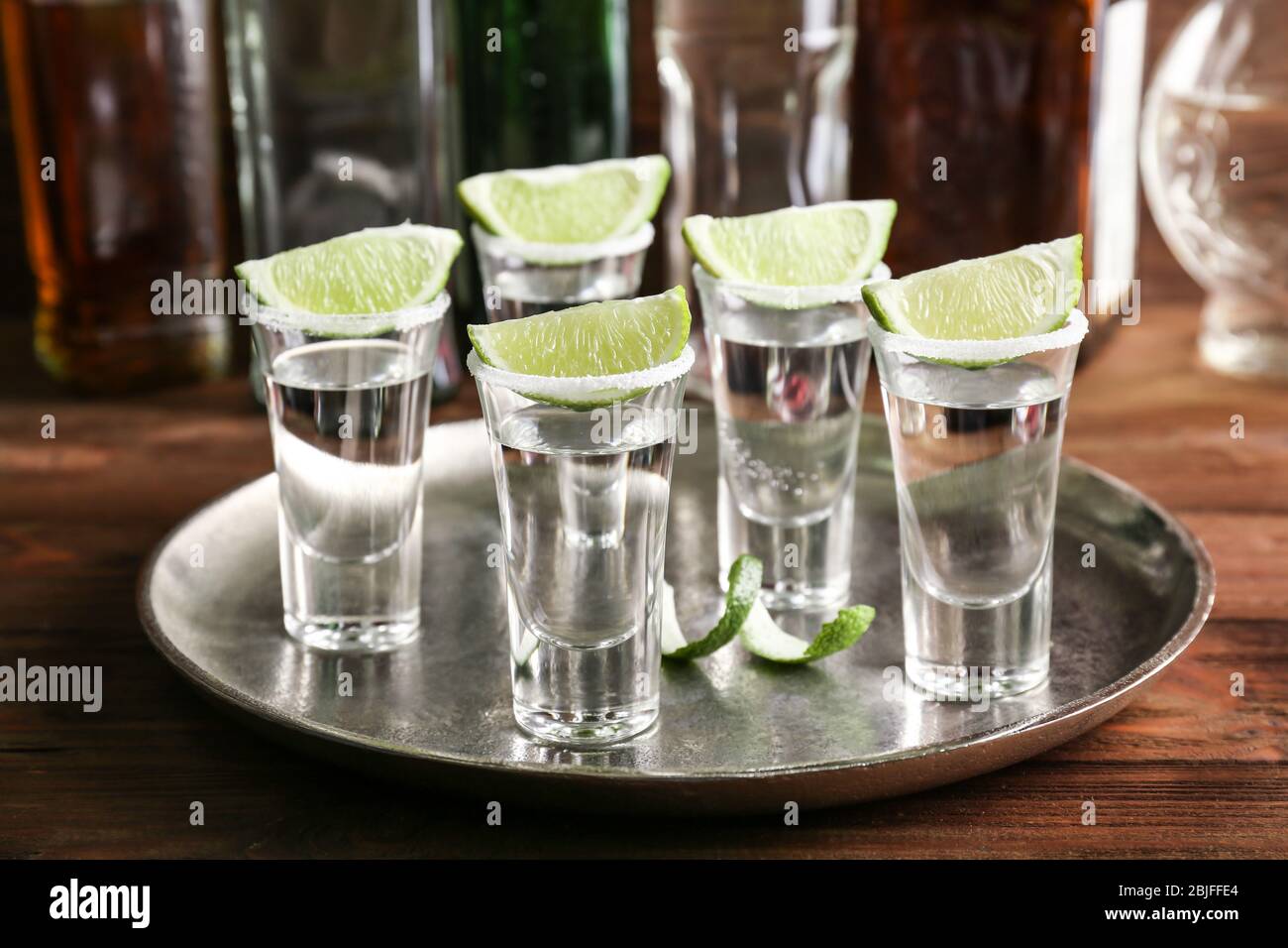 Tequila con succulente fette di lime e sale sul vassoio Foto Stock