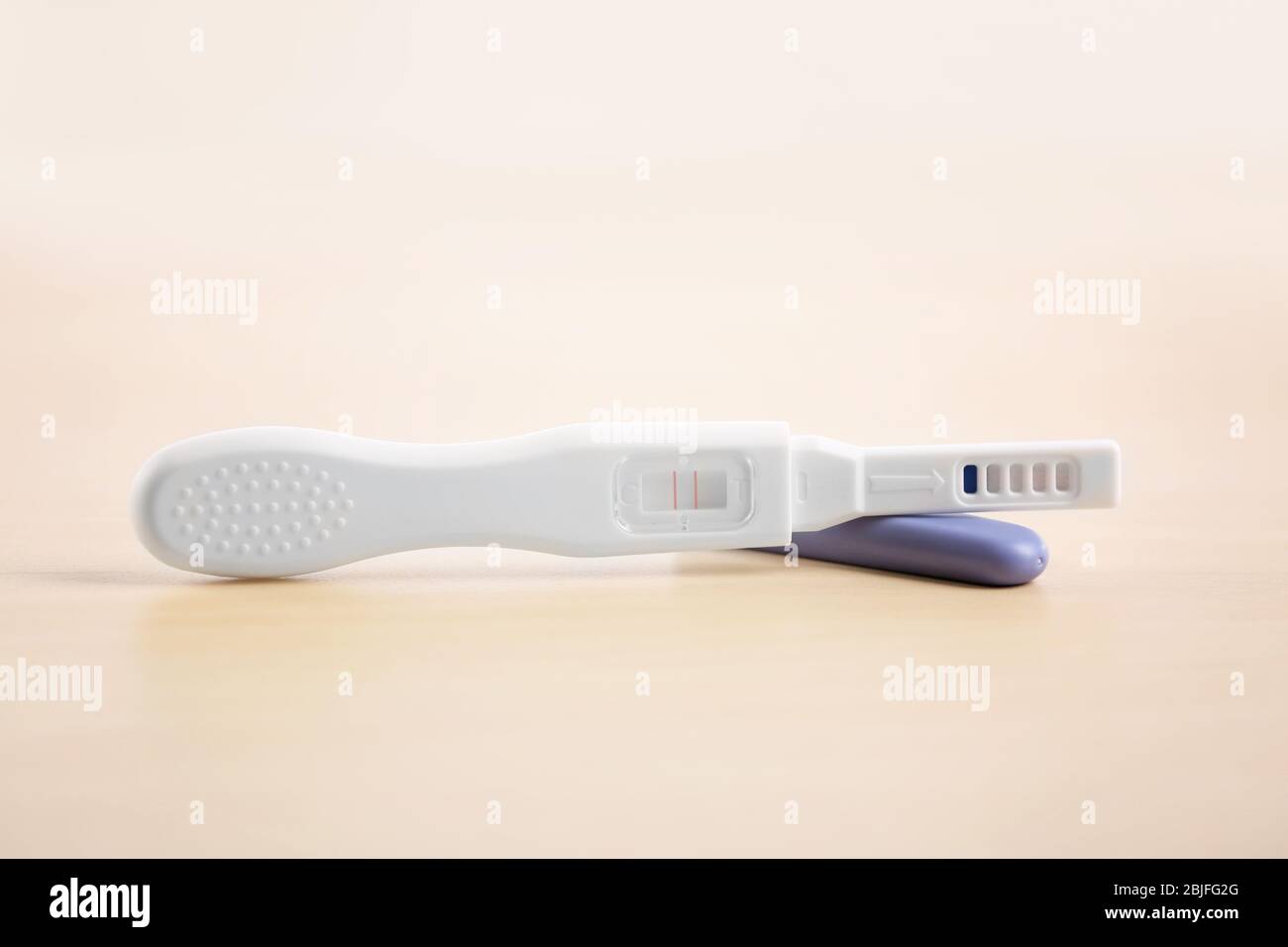 Test di gravidanza su tavolo di legno Foto Stock