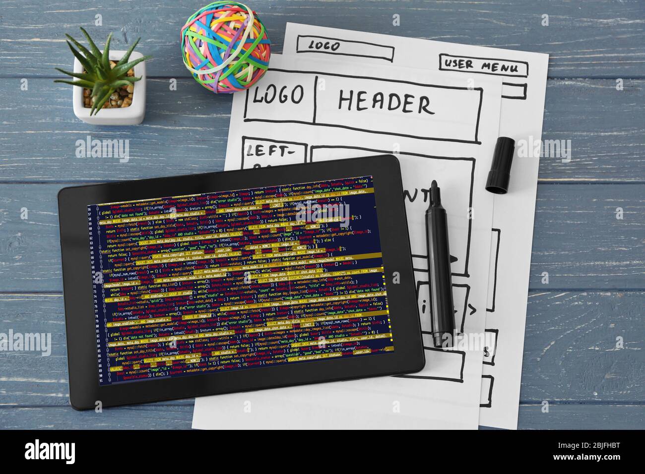 Tablet e diagrammi di flusso digitali su sfondo grigio in legno Foto Stock