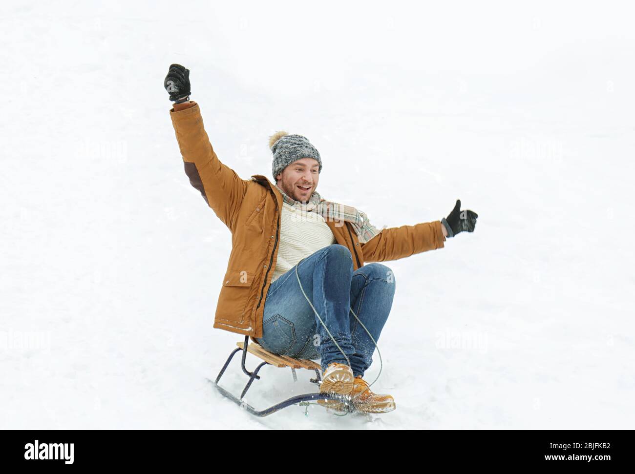 Uomo in slitta nel parco invernale Foto Stock
