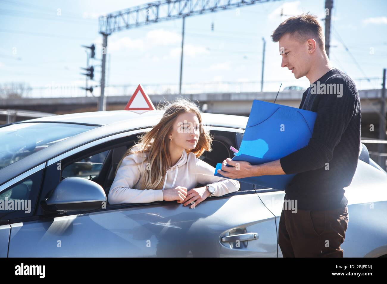 Istruttore di guida e studente donna in auto da esame. Foto Stock