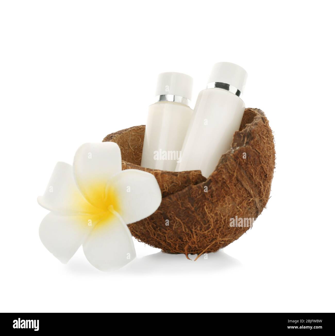 Bottiglie con crema di cocco e fiori tropicali su sfondo bianco Foto Stock