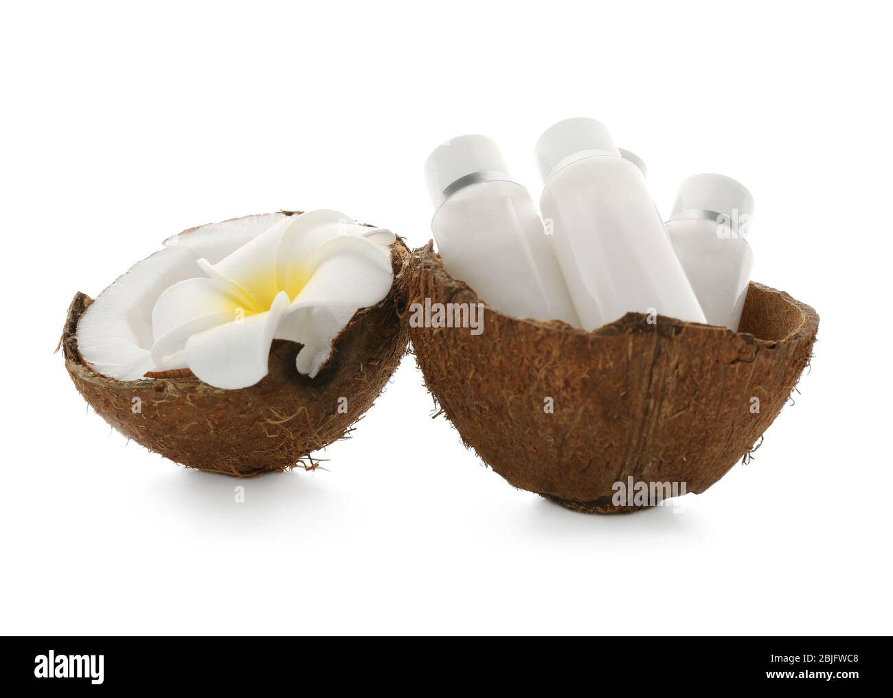 Bottiglie con crema di cocco con fiori tropicali su sfondo bianco Foto Stock