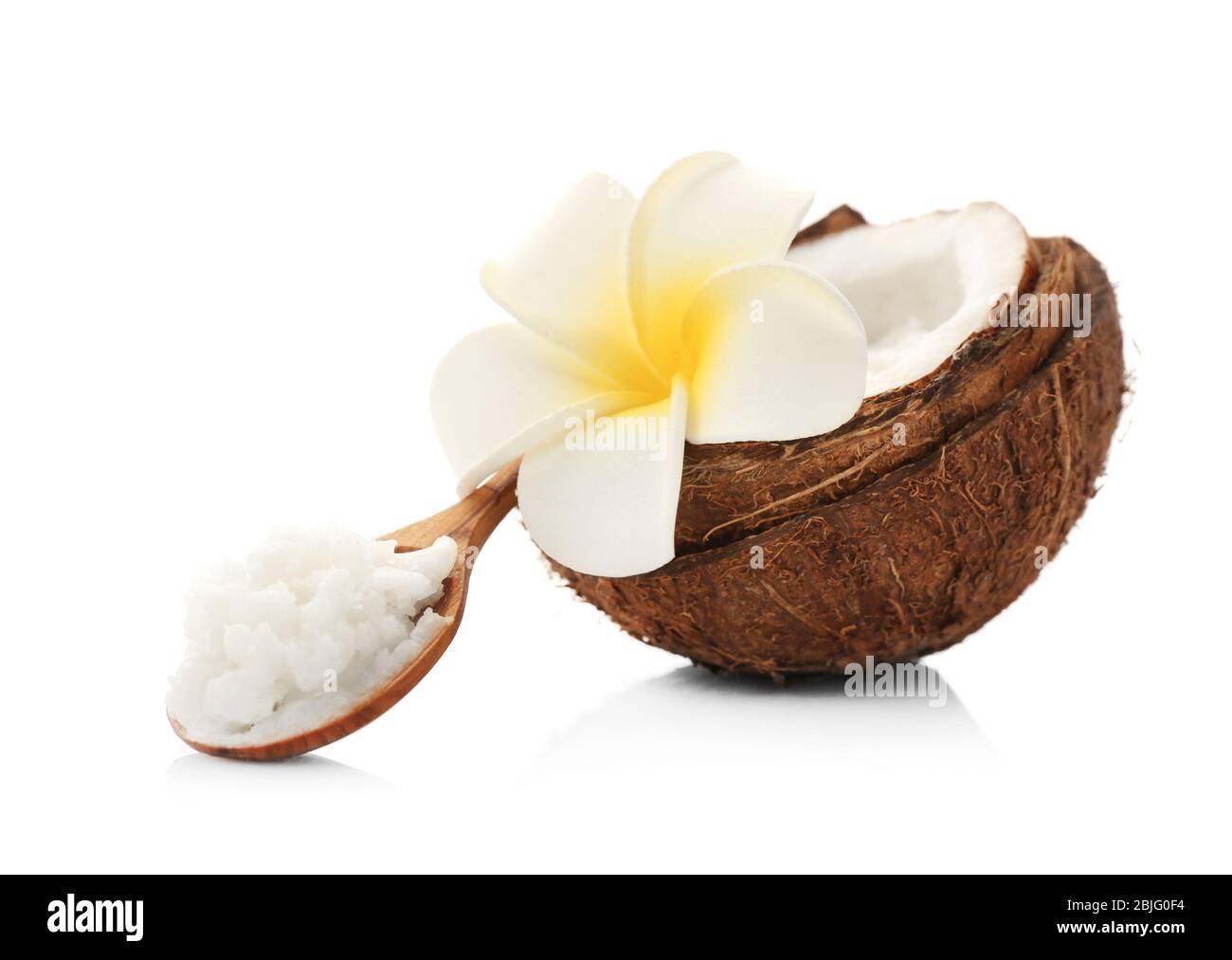 Composizione con burro di cocco in cucchiaio di legno e noce su fondo bianco Foto Stock