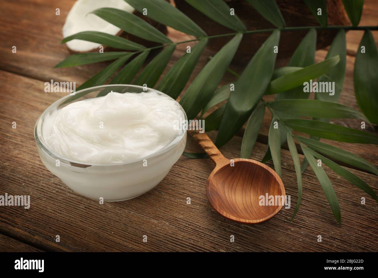 Ciotola con olio di cocco fresco su tavolo di legno Foto Stock