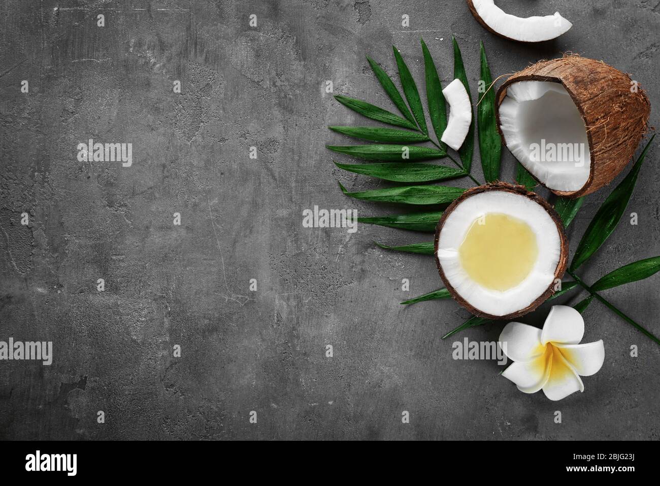 Olio di cocco fuso fresco in metà di noce sul tavolo Foto Stock