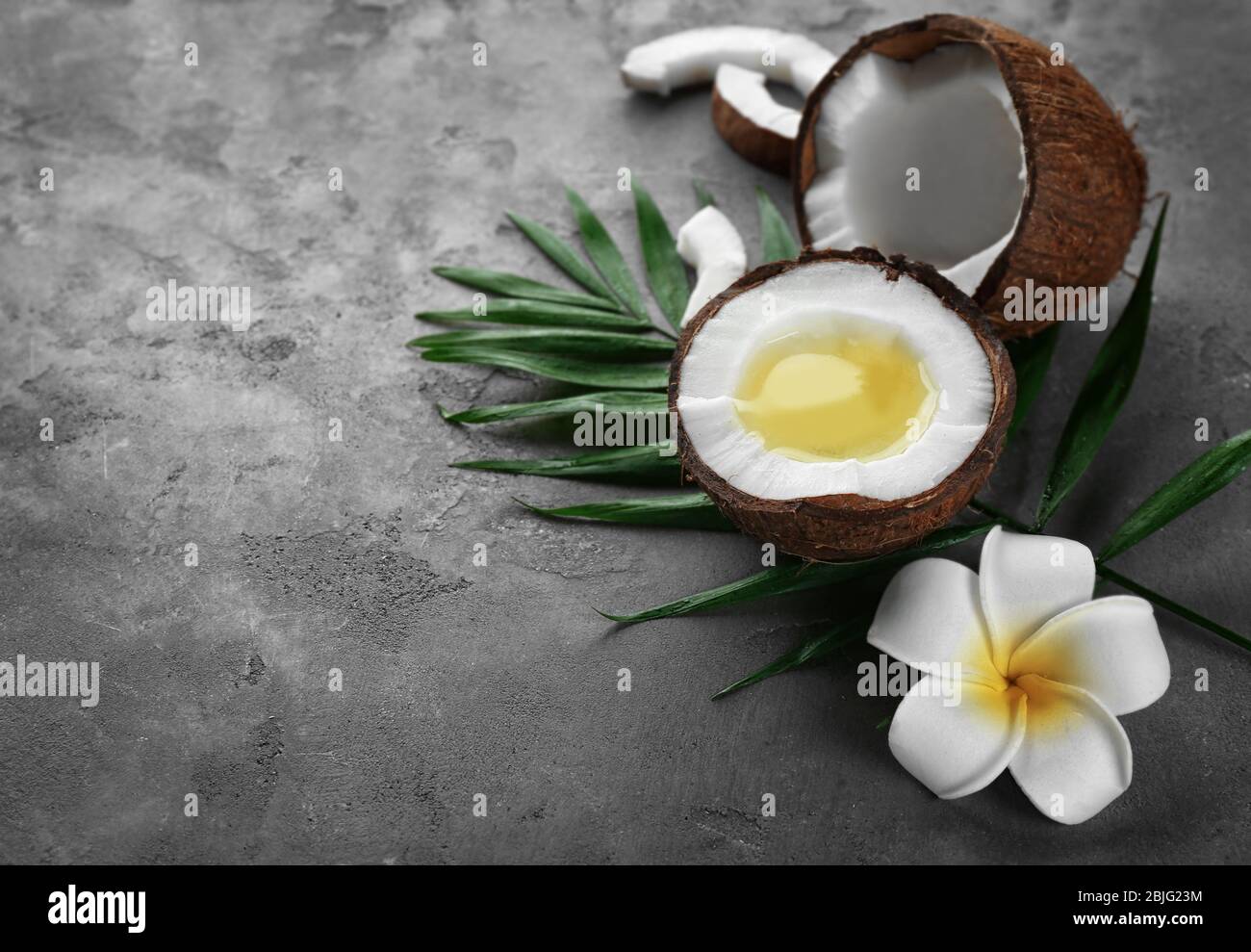 Olio di cocco fuso fresco in metà di noce sul tavolo Foto Stock