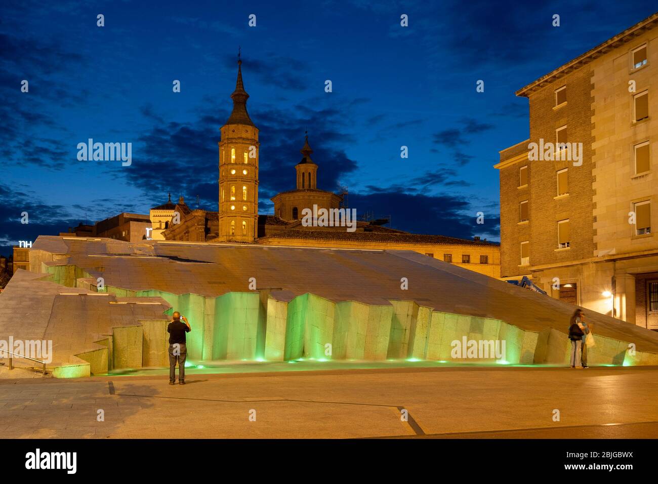 Vista notturna del Fuente de la Hispanidad illuminato con la chiesa Iglesia de San Juan de los Panetes sullo sfondo, Saragozza, Spagna Foto Stock