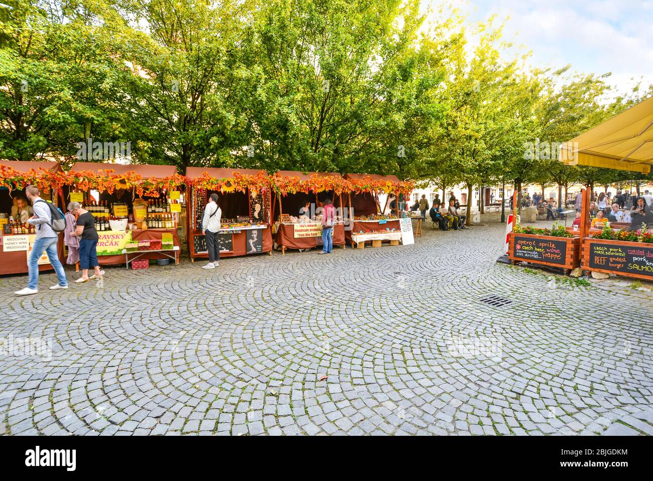 I turisti possono godersi una giornata di shopping e ristoranti in autunno presso i caffè della piazza del mercato di Kampa Island vicino al Ponte Carlo di Praga, Repubblica Ceca Foto Stock
