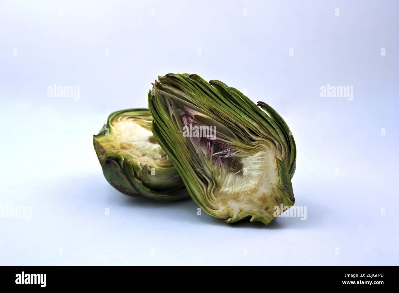 Immagine di un carciofo diviso in due metà su una superficie neutra e spazio per testi (spazio per copia) Foto Stock
