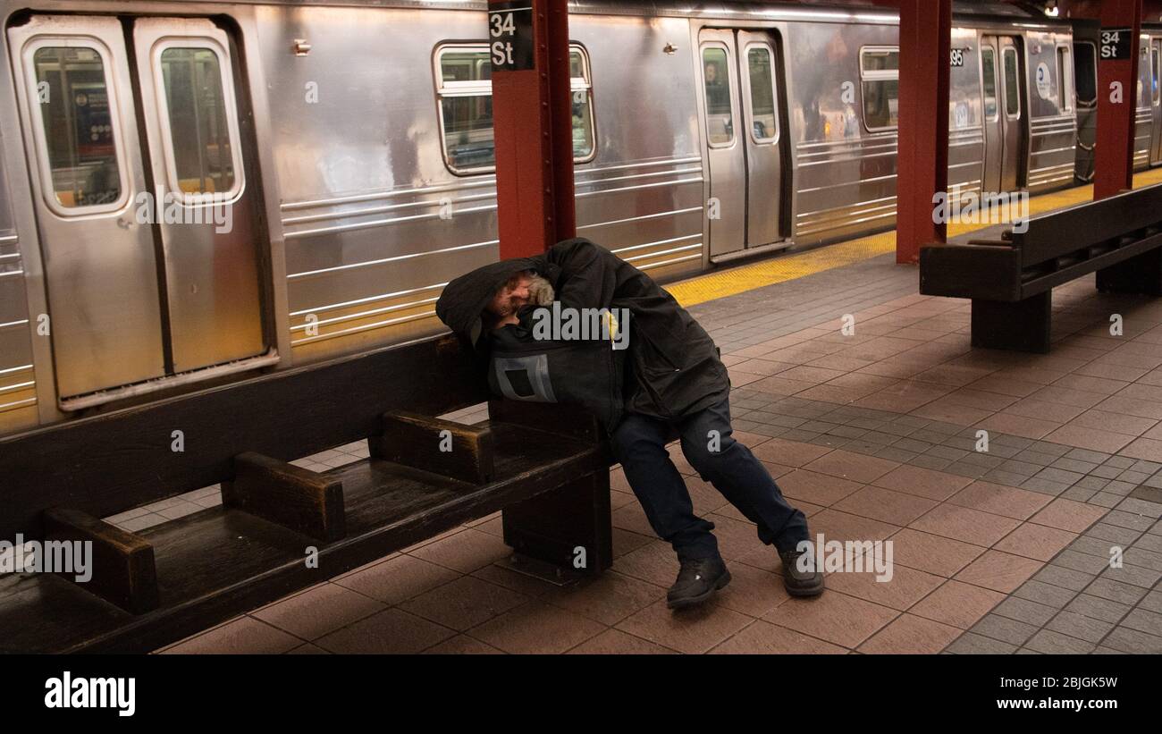 New York, Stati Uniti. 29 aprile 2020. Un uomo senza tetto addormentato su una panchina nella metropolitana di NYC in mezzo al coronavirus BREP.New York City continua a combattere la pandemia coronavirus ed è un effetto economico come il governatore di New York annuncia i requisiti per iniziare un'attenta 'passo dopo passo' riapertura dello stato. Credit: Braulio Jatar/SOPA Images/ZUMA Wire/Alamy Live News Foto Stock