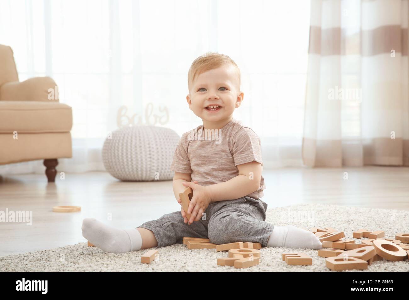 Carino bambino che gioca con le lettere a casa Foto Stock