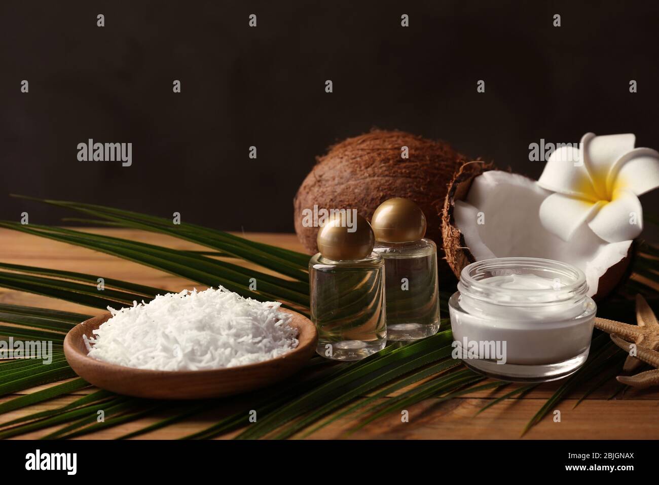 Composizione Spa con prodotti per la cura del corpo e cocco su sfondo di legno Foto Stock