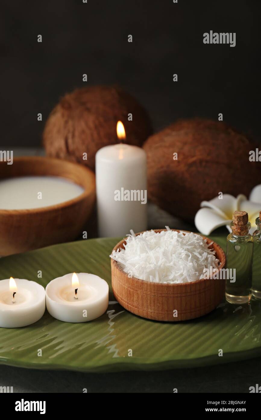 Bella composizione spa con prodotti per la cura del corpo al cocco e candele sul tavolo Foto Stock
