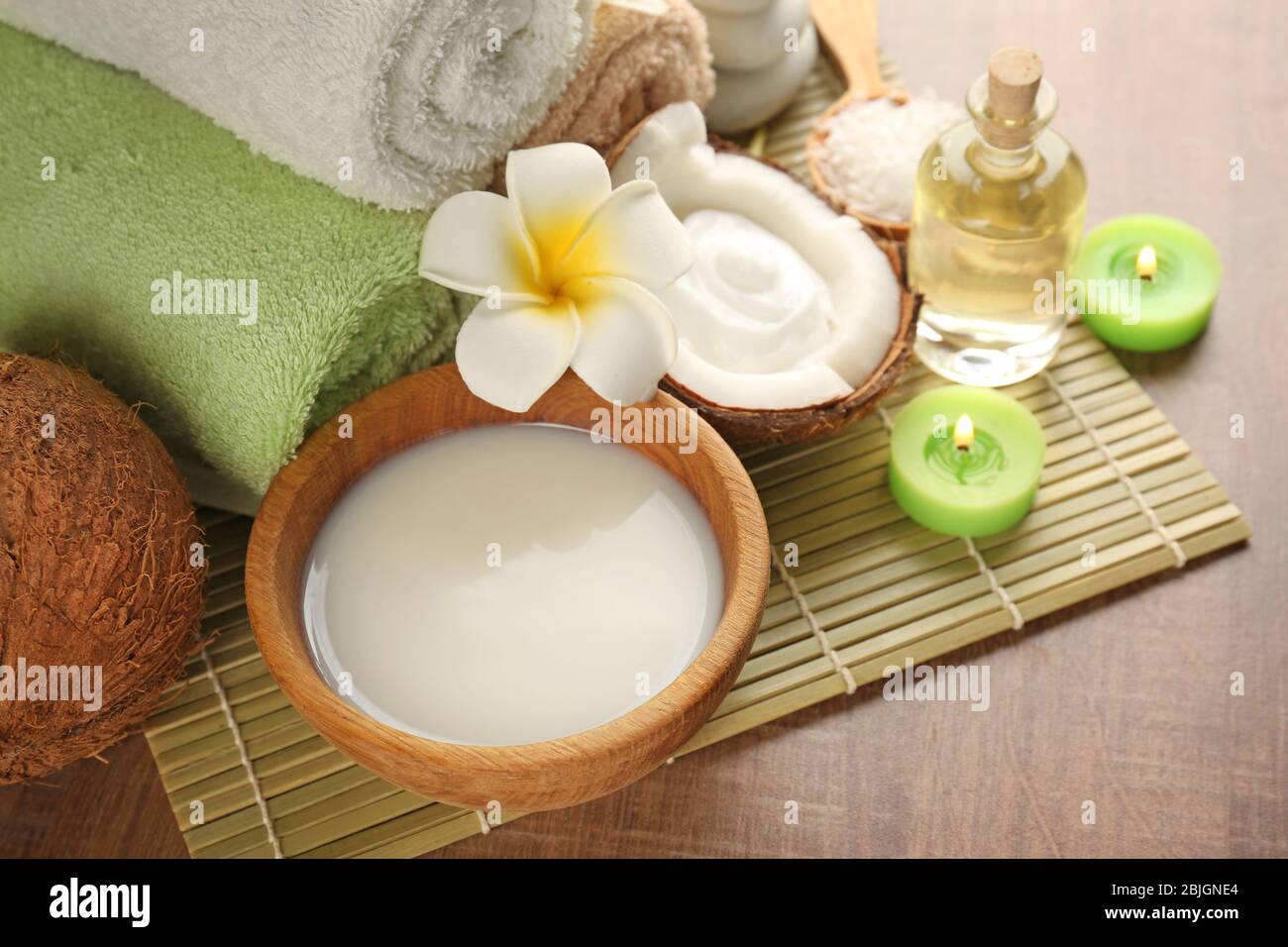 Bella composizione spa con prodotti per la cura del corpo al cocco su tappetino di bambù Foto Stock