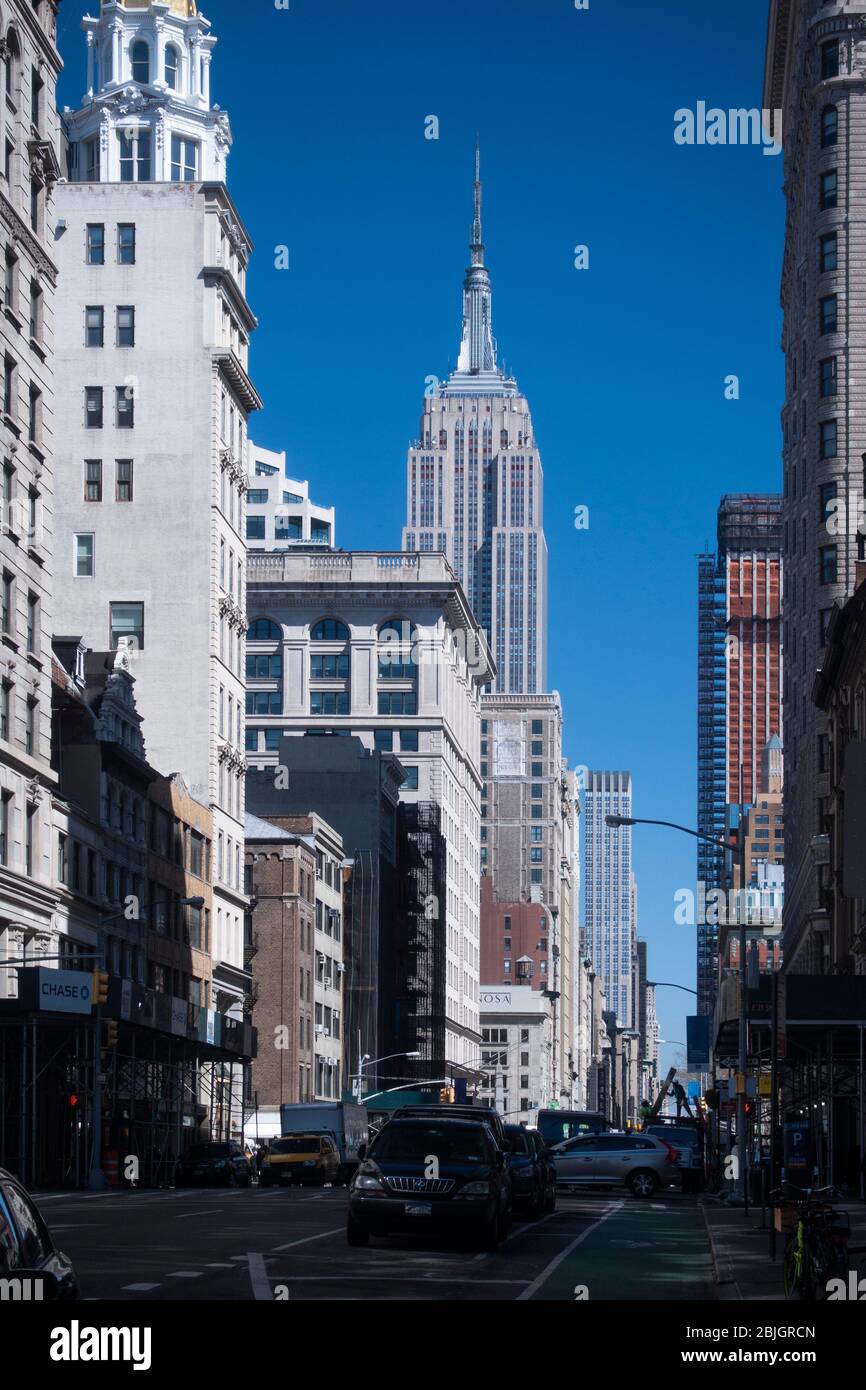 Empire state Building dalla strada che guarda lungo un viale di New York Foto Stock