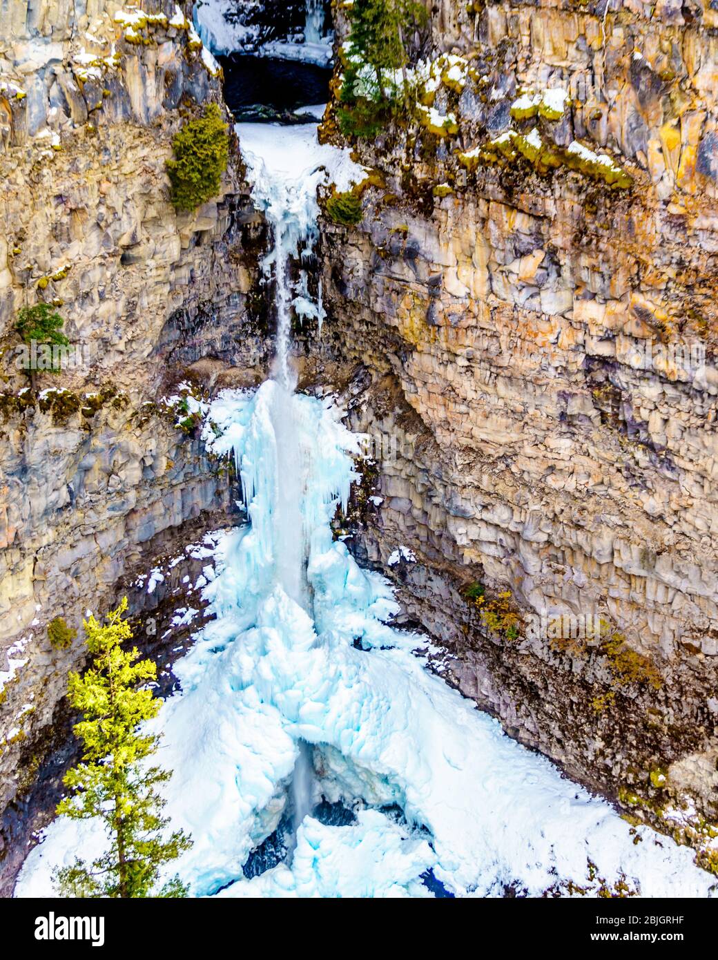 Lo spettacolare cono di ghiaccio e neve in inverno, in fondo alle cascate di Spahats, sul fiume Spahats, nel Wells Gray Provincial Park, BC, Canada Foto Stock