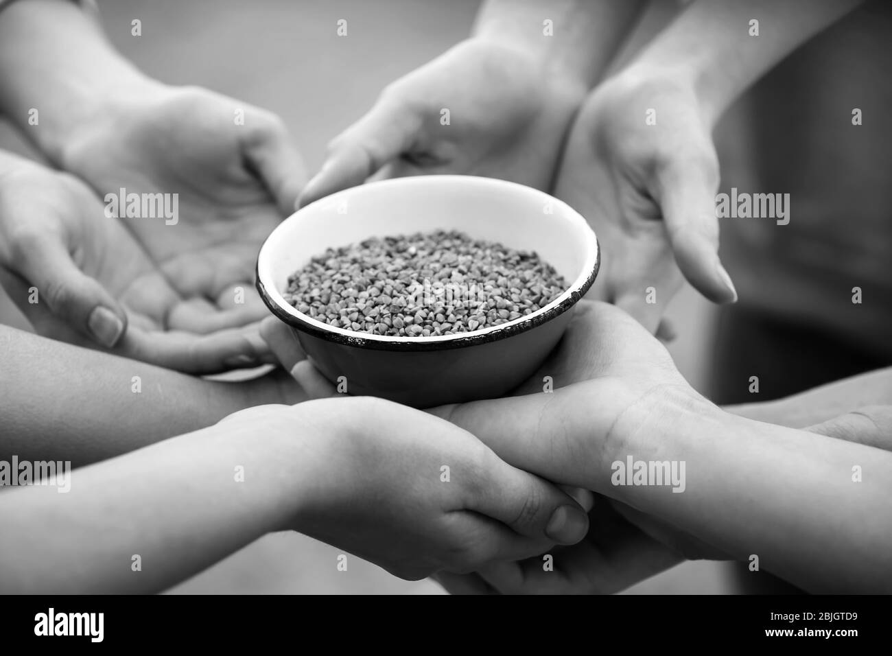 Persone povere che tengono la ciotola con grano saraceno Foto Stock