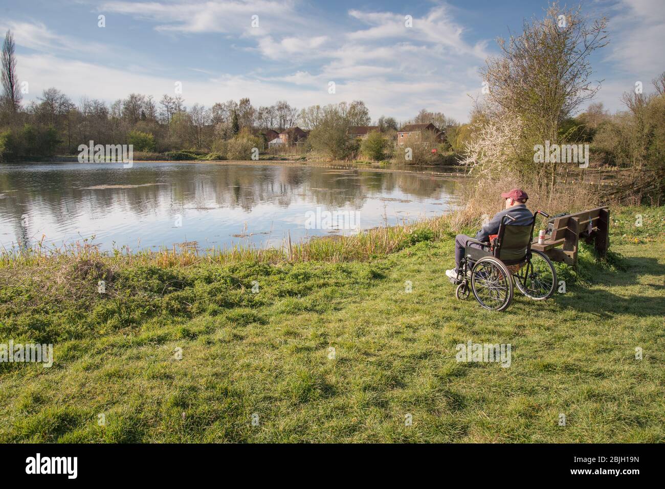 Anziano maschio a metà degli anni novanta che soffre di demenza trova pace nel vedere le acque calme e ascoltare i suoni della natura. Foto Stock