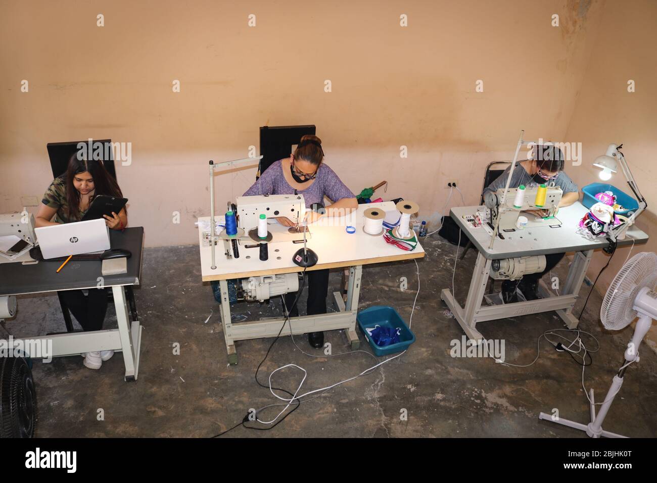 Torreon, Messico. 28 Aprile 2020. Le donne siedono in un piccolo laboratorio e cucono i paraluci contro il virus corona nello stile delle maschere colorate della Lucha Libre - una versione messicana di lotta. Poiché i lottatori messicani non sono autorizzati a combattere nella crisi corona, sono passati alla produzione di coloratissimi collutori per tenere la testa sopra l'acqua. (Al dpa 'gladiatori' exican lotta con macchine da cucire contro Corona' da 30.04.2020) Credit: Carlos Castañeda/dpa/Alamy Live News Foto Stock