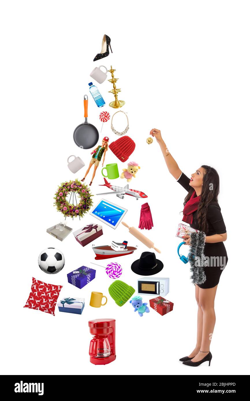 Giovane donna che decora un albero di Natale fatto con i regali. Foto Stock