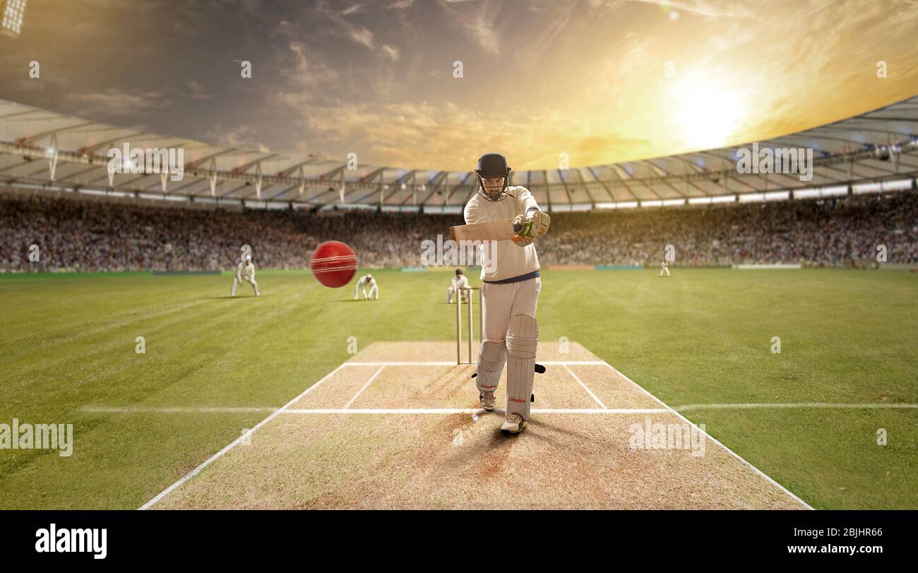 Il giovane sportivo colpisce la palla mentre batte nel campo di cricket Foto Stock