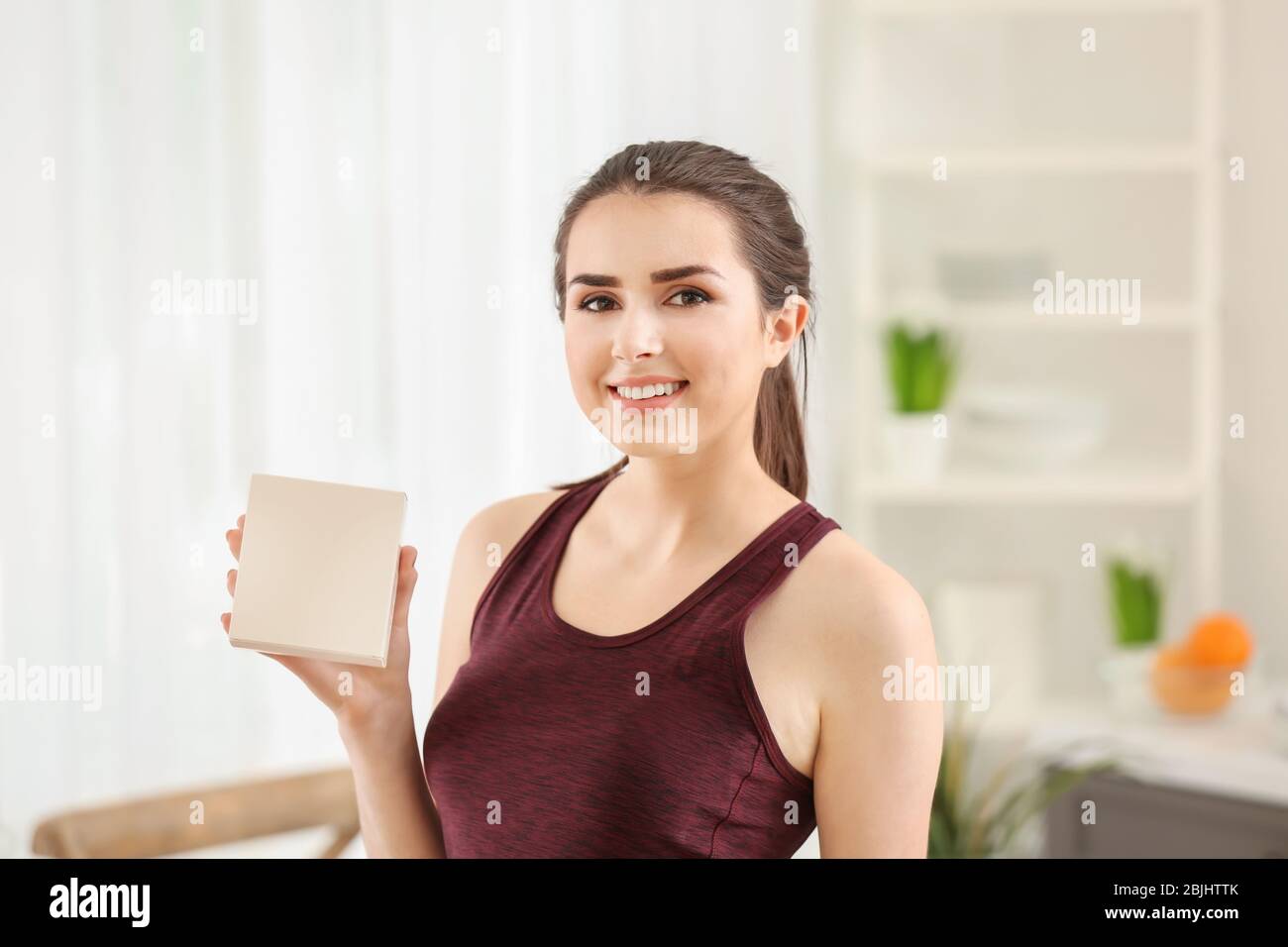 Bella giovane donna biologicamente attivi in supplemento a casa. Concetto di dieta Foto Stock