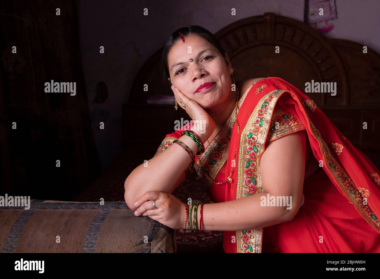 donna seduta a letto e sorridente Foto Stock