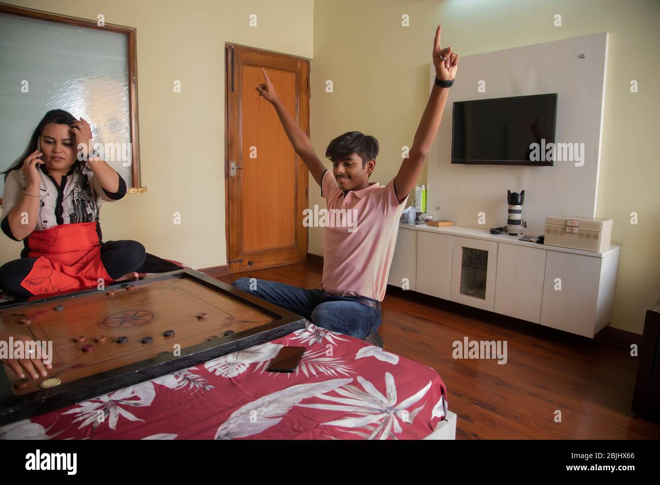Figlio che gioca a carrom-board con la madre a casa. Foto Stock