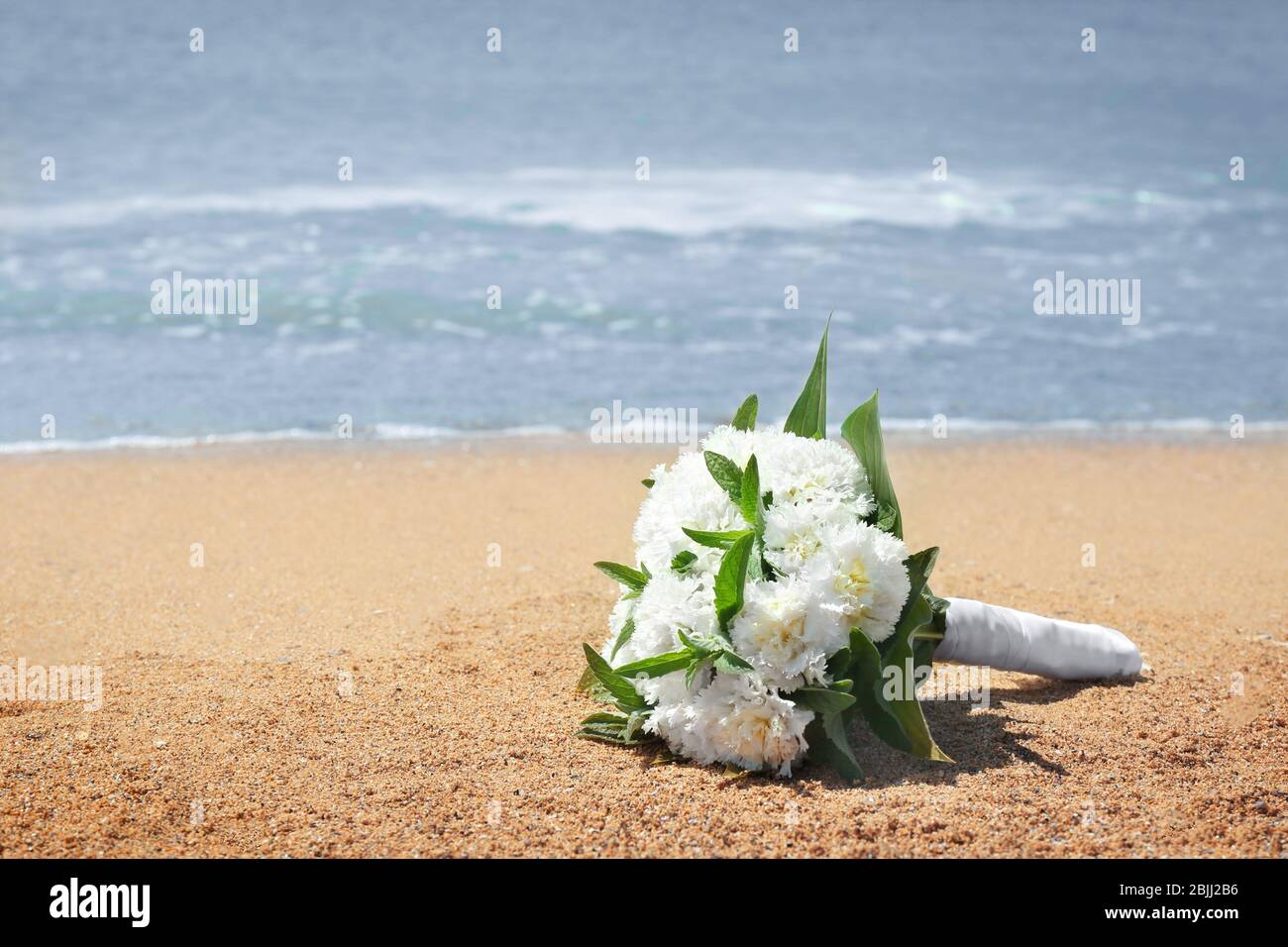 Bellissimo bouquet sulla sabbia. Concetto di matrimonio in spiaggia Foto Stock