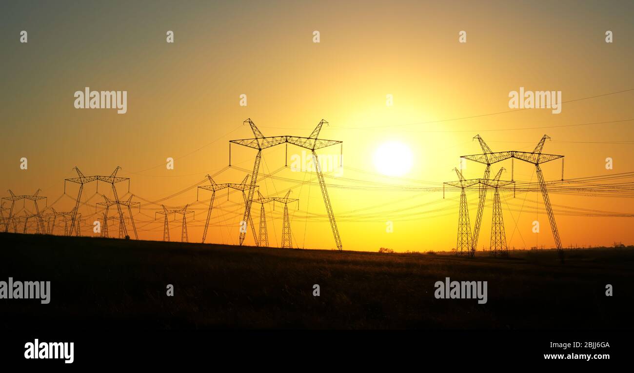 Torre elettrica ad alta tensione al tramonto. Tramonto cielo sfondo. Torre di alimentazione Foto Stock